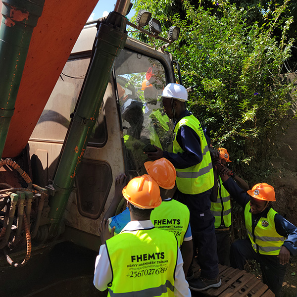 Excavator trainees carrying out safety procedures by conducting machine inspection